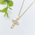 Dettaglio in primo piano di una collana con ciondolo a croce dorata e pietre bianche lucenti. - Stile Croce Zirconia (XL1200-31) / Oro