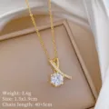 Primo piano dettagliato di una raffinata collana con ciondolo dorato e zircone splendente. - Stile Pendente con Diamante Singolo (XL2606-407) / Oro