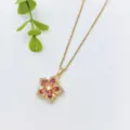 Vista dettagliata della delicata collana con ciondolo floreale dorato e pietre rosa brillanti. - Stile Fiore Pietra Rossa Dorata (XL1992-168)