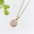 Primo piano di una delicata collana a catena dorata con pendente in resina rosa. - Stile Rotondo Rosa (XL2190-029)