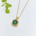 Primo piano di una collana con ciondolo a alone dorato e uno zircone verde centrale luminoso. - Stile Quadrato di Alta Gamma (XL1431-7)