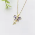 Primo piano dettagliato di una collana con farfalla in oro, zircone viola e ciondolo stella - Farfalla Diamante Viola (XL2118-2)