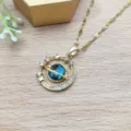 Primo piano dettagliato della elegante collana con ciondolo pianeta Saturno in oro con zirconi luminosi. - Catena Labbra con Stella Rotonda da Sogno (XL1992-101)
