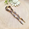 Primo piano dettagliato di un elegante fermacapelli in acetato tartarugato per acconciature. - Tartaruga Ambra