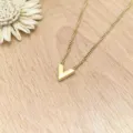 Detailed close-up view of a minimalist gold V-shaped pendant necklace on wooden backdrop. - XL1338-17 Gold Color