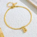 Gros plan détaillé du bracelet de cheville en chaîne serpent dorée avec pendentif lettre B. - Lettre B