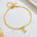 Nahaufnahme einer goldenen Schlangenkette Fußkette mit Buchstaben Anhänger und K18. - Buchstabe I