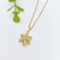 Gros plan détaillé du collier pendentif fleur en or élégant avec des pierres étincelantes. - Fleur Dorée