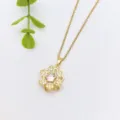 Gold flower pendant necklace with shimmering zircon stones, exquisite detail shot showing delicate chain. - Gold Rotating Flower