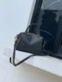Black genuine leather Boston bag detail shot, premium cowhide crossbody handbag with gold hardware. - Black