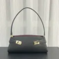 Detailed view of black leather shoulder bag with contrast burgundy lining and gold hardware. - Blank / Black