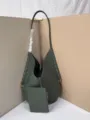 Closeup detail of dark green woven leather shoulder tote bag with small matching pouch. - Slate