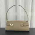 Taupe leather baguette shoulder bag detail showcasing elegant gold metal hardware design. - Blank / Khaki