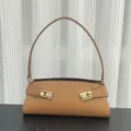 Detail view of stylish tan leather shoulder bag with chic gold hardware buckle design. - Blank / Gold Brown