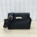 Detalle en primer plano del bolso de cuero negro con cierre de cerradura de metal. - Negro
