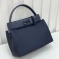 Close-up detail view of the dark blue genuine leather handbag with metallic pyramid stud strap. - Midnight Blue