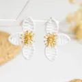 Elegante weiße geflochtene Blumenohrringe mit Goldmitte, schicker botanischer Schmuck. - Weiß