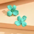 Detailed close-up shot of mint green flower stud earrings with sparkling green crystal center. - Lake Green