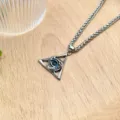 Detail view of the stylish devil eye triangular pendant necklace with wheat chain on wooden table. - Keel Chain Necklace XL0958-2