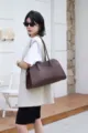 Classic East-West leather tote bag in dark brown with pebbled texture and long handles. - Ebony