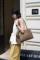 Detailed view of brown pebbled leather shoulder bag with long handles, street style. - Letter Style / Elephant Gray