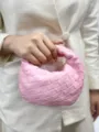 Pink woven leather handbag detail showing exquisite braided texture and compact artisan craftsmanship. - Pink