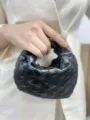 Detailed shot of black woven leather handbag, premium handmade intrecciato design. - Black