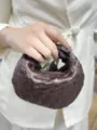 Detail shot of the dark brown woven leather handbag showing exquisite craftsmanship and texture. - Coffee