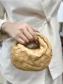 Detailed view of woven leather handbag detail, classic intrecciato design and texture. - Taupe