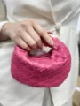 Detailed view of the pink woven leather handbag showing exquisite craftsmanship and texture. - Hot Pink