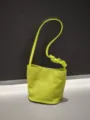Détail du sac seau en cuir vertlime avec bandoulière nouée unique et texture souple. - 16*11*18cm / Vert Fruit
