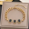 Detailaufnahme eines goldfarbenen Titanstahl-Armbands mit drei schwarzen Quadraten - Schwarzes Rechteckiges Emaille-Armband (5263) / Goldschwarz