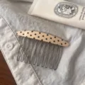 Detailed view of the chic polka dot acetate hair comb with metal tines, ideal for styling bangs. - Milky White Black Dot