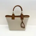 Canvas leather tote bag with stylish stirrup charm and spacious design for everyday use. - Off-white and Brown Contrast