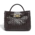 Close-up view of the dark brown woven leather handbag featuring luxury gold-tone knot hardware. - Grape Purple