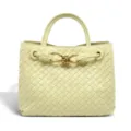 Detailed view of pale yellow woven leather tote bag with elegant metallic knot hardware. - Light Yellow
