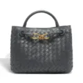 Detailed view of the dark grey woven leather handbag featuring elegant metal knot closure. - Iron Gray