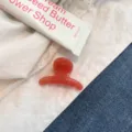 Primo piano dettagliato di una molletta per capelli gelatinosa traslucida su tessuto bianco. - Stile Mini Appendino Rotondo / Rosa Fragola Gelatina