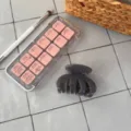 Nahaufnahme einer grauen Haarklammer auf gefliester Oberflaeche mit Make-up-Requisiten. - Vier-Zahn Unregelmäßige Kralle / Hell Silbergrau