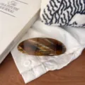 Detailed view of large oval hair clip with stylish tortoise shell pattern and golden lettering. - Melon Seed Gold Label Spring Clip / Coffee Pattern