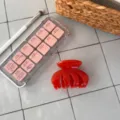 Detailaufnahme einer schicken roten Haarklammer mit vier Zähnen für elegante Frisuren. - Vier-Zahn Unregelmäßige Kralle / Orangerot