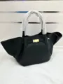 Black leather winged handbag with top handle and metal closure, stylish daily tote bag for women. - Solid Color Style / Black