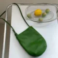Borsa a tracolla minimalista in morbida pelle verde scuro, elegante accessorio quotidiano. - Verde
