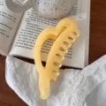 Primer plano detalle de una linda pinza para el pelo acrílica amarilla en forma de corazón. - 12.5cm / Amarillo Gelatina