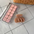 Detailansicht einer schicken karamellbraunen Haarklammer auf einer modernen grauen Fliese. - Vier-Zahn Unregelmäßige Kralle / Dunkles Nude-Rosa
