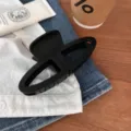 Detalle de pinza de pelo geométrica negra, diseño minimalista para peinados diarios elegantes. - Negro Mate