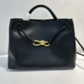 Schwarze Handtasche aus Leder mit geflochtenen Riemen und goldenem Knoten für Damen. - Schwarz