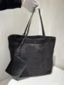 Detailed view of a black woven raffia tote bag with leather straps and attached pouch. - Small 27*16*28 Letter / Black
