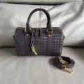 Dark brown woven leather boston bag detail showing intricate intrecciato craftsmanship. - Coffee