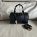 Black leather woven boston handbag with top handles and strap. Classic chic design. - Black